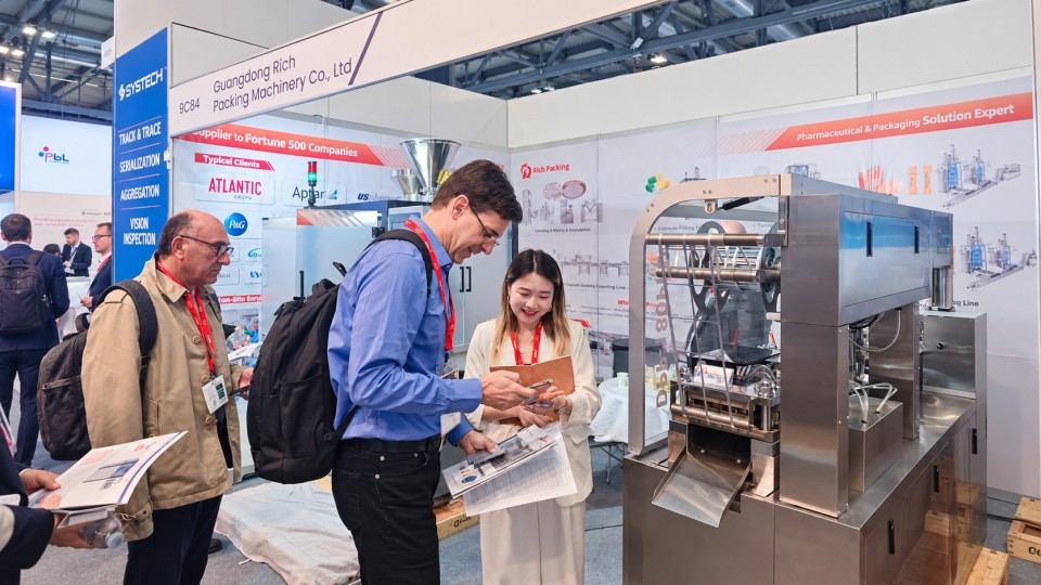 Visitors speak with Rich Packing representative Sara at booth 9C84